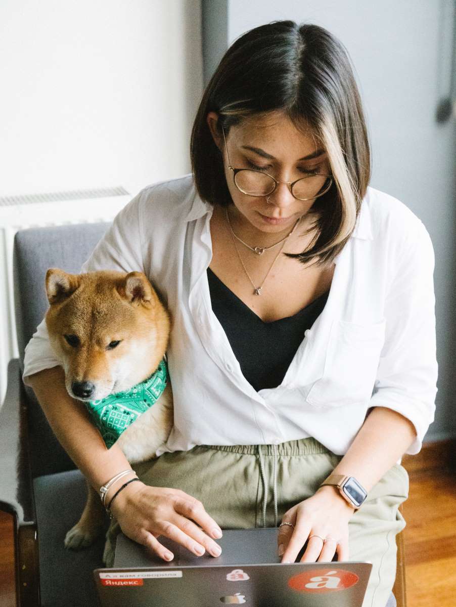 Woman with dog working on dog bakery business marketing on her computer